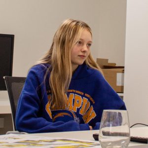 Emma sat at a table looking into the distance