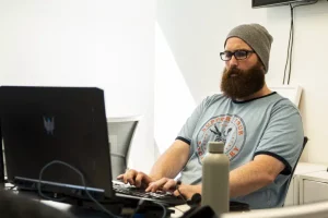 Liam sat by a black computer