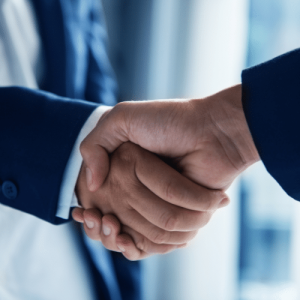 Two people wearing suits shaking hands