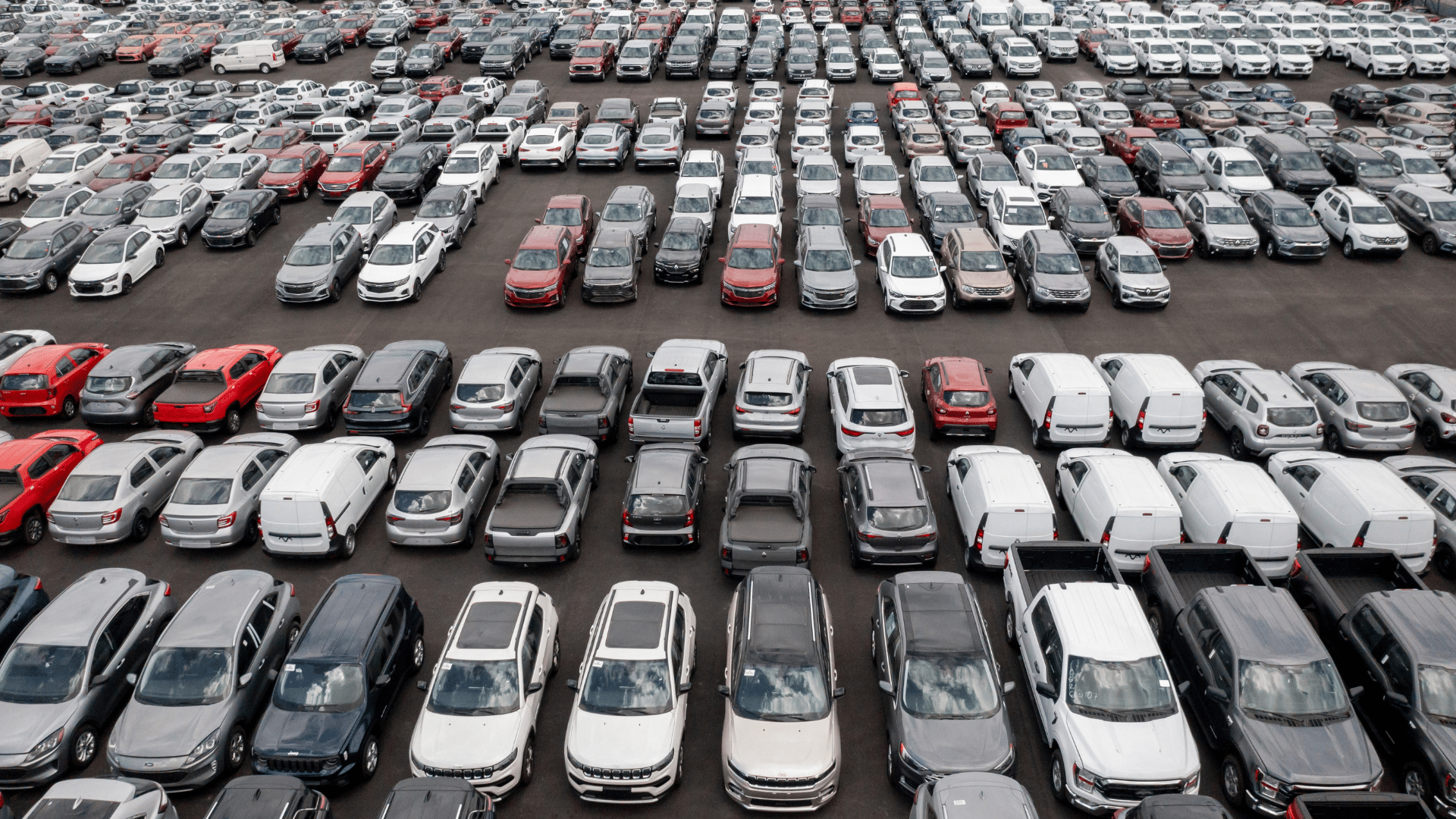 birds eye view of new cars parked in an orderly fashion prepared for inspection